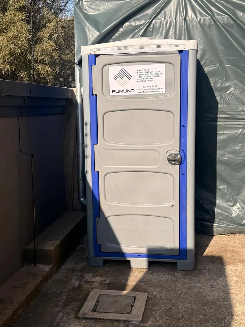 Close-up of a Fumuno standard portable toilet door with the Fumuno service list decal, phone number and website — chemical toilet hire across Gauteng.