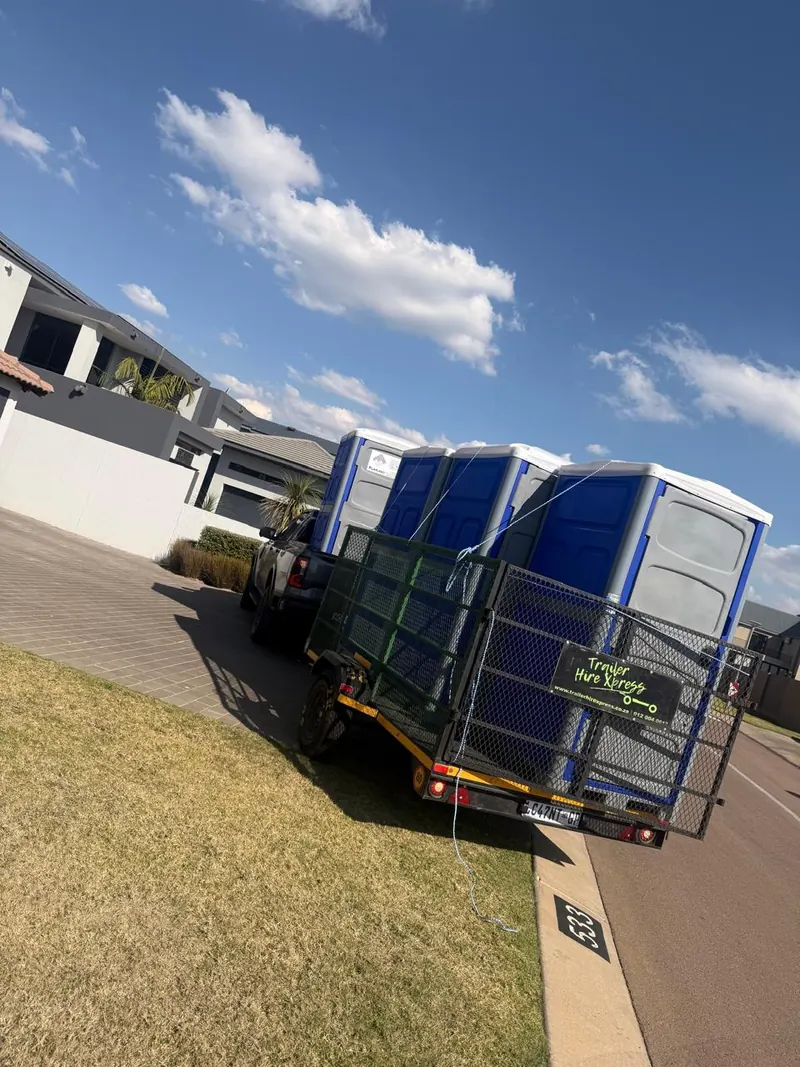 Fumuno portable toilets strapped to a delivery trailer behind a bakkie outside a home in Gauteng