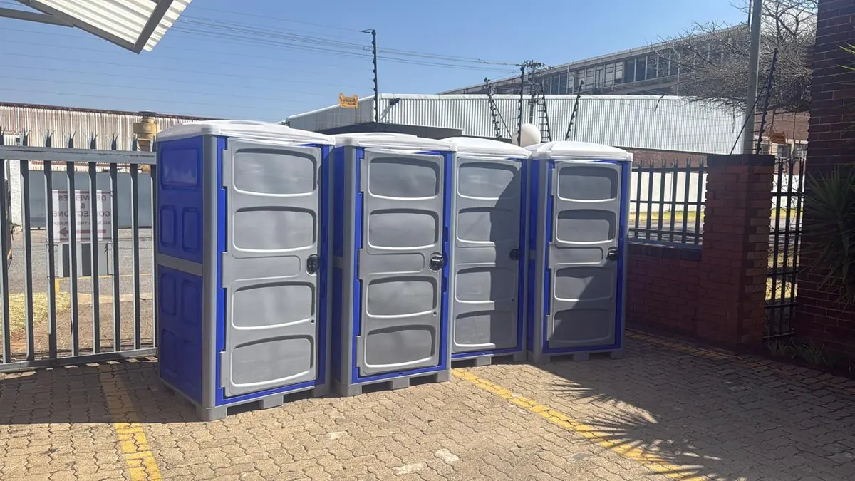 Four clean Fumuno blue and grey portable chemical toilets lined up at the Fumuno depot in Gauteng