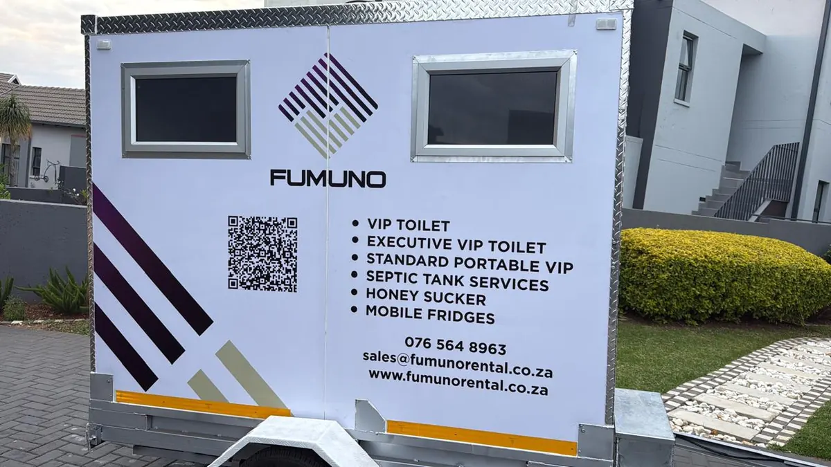 Front of a Fumuno VIP mobile toilet trailer showing branded service list — VIP toilets, mobile fridges, septic services — with QR code