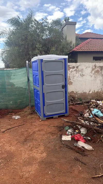 Fumuno blue and grey standard portable chemical toilet placed on a residential building site in Gauteng, providing on-site sanitation for construction workers.